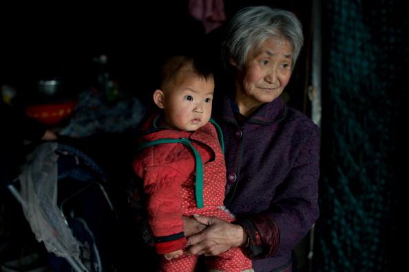 En kvinna med sitt barnbarn i staden Chengde i Hebeiprovinsen, den 21 mars 2013. I Chengde är invånarna inte bundna av Kinas ettbarnspolitik. Ettbarnspolitiken diskuterades på denna veckas partitoppmöte. (Foto: Ed Jones/AFP/Getty Images)
