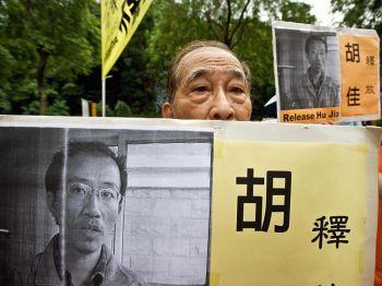 En äldre man höll ett plakat med en bild av den fängslade kinesiske människorättskämpen Hu Jia vid en demonstration i Hongkong den 7 juli 2008. (Foto: Andrew Ross/AFP/Getty Images)