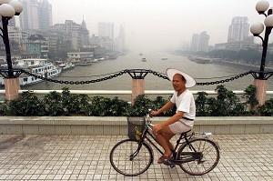 En man cyklar på bron över Pärlfloden i Guangzhou. (Foto: Peter Parks/AFP/Getty Images)