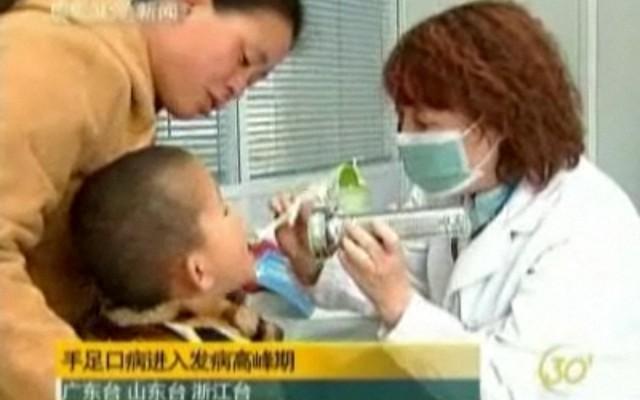 Sjukvårdspersonal undersöker barn som befaras bära farlig smitta. (Foto: skärmbild från NTDTV)