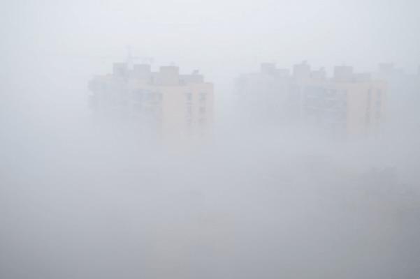 Två flerbostadshus är nätt och jämnt skönjbara i tät smog den 30 januari i Hangzhou i Zhejiangprovinsen, södra Kina. Kinas centrala meteorologiska station varnade för tät dimma i 11 provinser i östra, södra och centrala Kina. (Foto: Weibo.com)