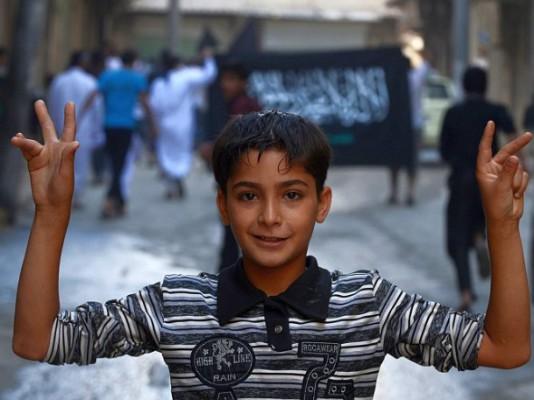 En syrisk pojke gör segertecknet under en anti-regimdemonstration i den norra staden Aleppo den 19 oktober 2012. (Tauseef Mustafa/AFP/Getty Images)