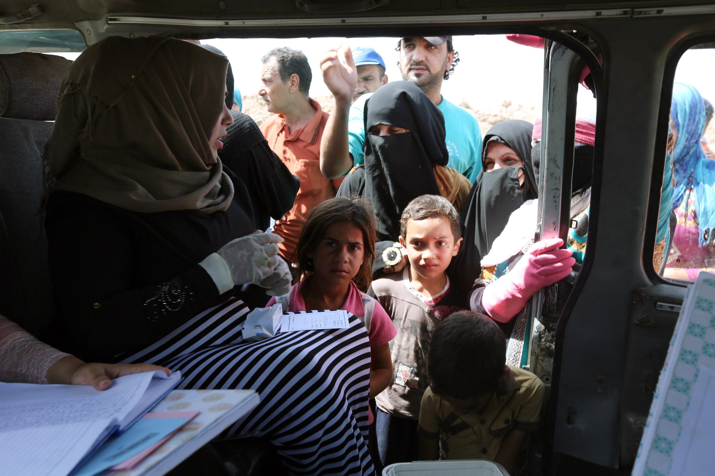 Hälsovårdspersonal sitter i en bil och förbereder vaccination mot kolera i ett flyktingläger för internflyktingar i Irak, där ett kolerautbrott har spridit sig i 15 av 18 provinser. (Foto: Sabah Arar /AFP/Getty Image)