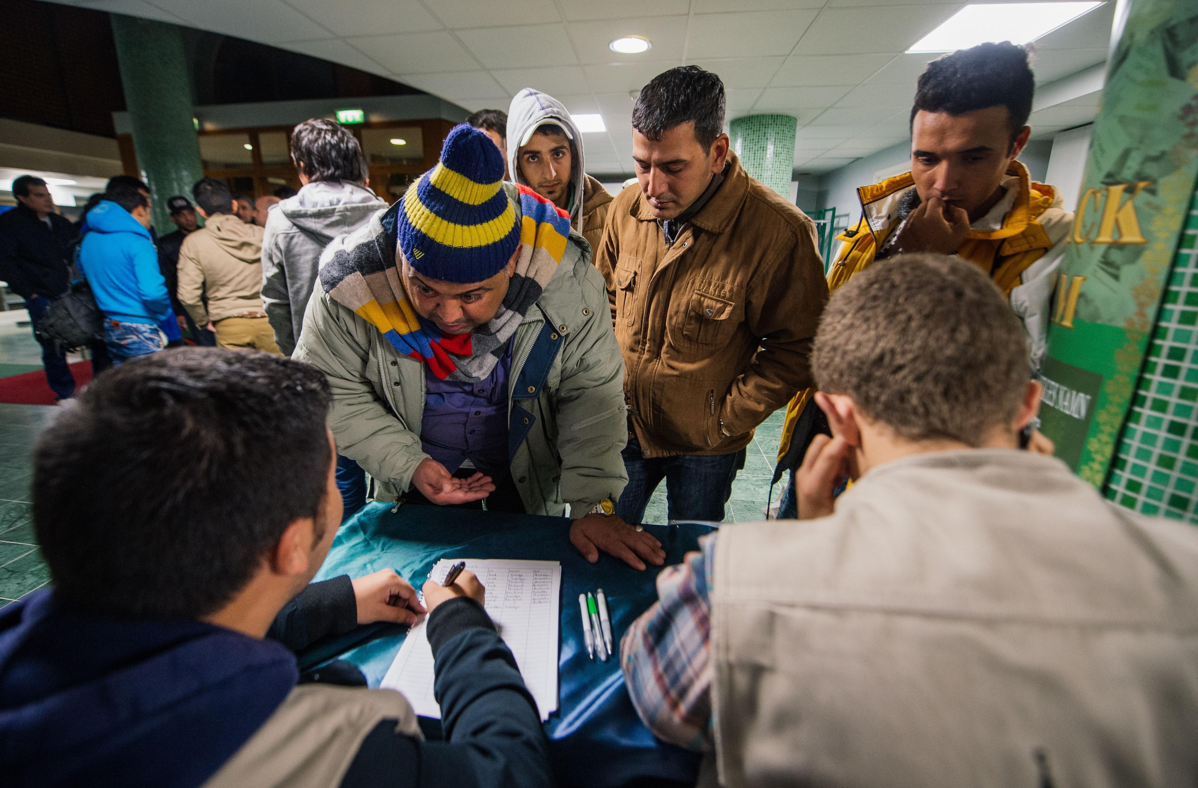  Flyktingar tas emot och registreras den 16 oktober i Stockholm. Regeringen föreslår att en allt större del av biståndet ska läggas på flyktingmottagandet i Sverige. Utsatta ställs emot varandra när biståndet minskas, menar svenska hjälporganisationer. (Foto: Jonathan Nackstrand/AFP/Getty Images)