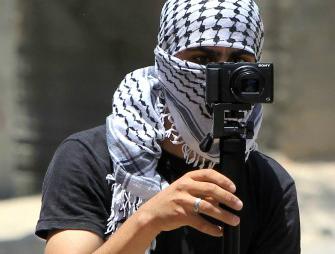 En demonstrant filmar en sammandrabbning efter en demonstration i juni 2015. Sociala medier ökar våldet i Israel. (Foto: Jaafar Ashtiyeh /AFP/Getty Image)