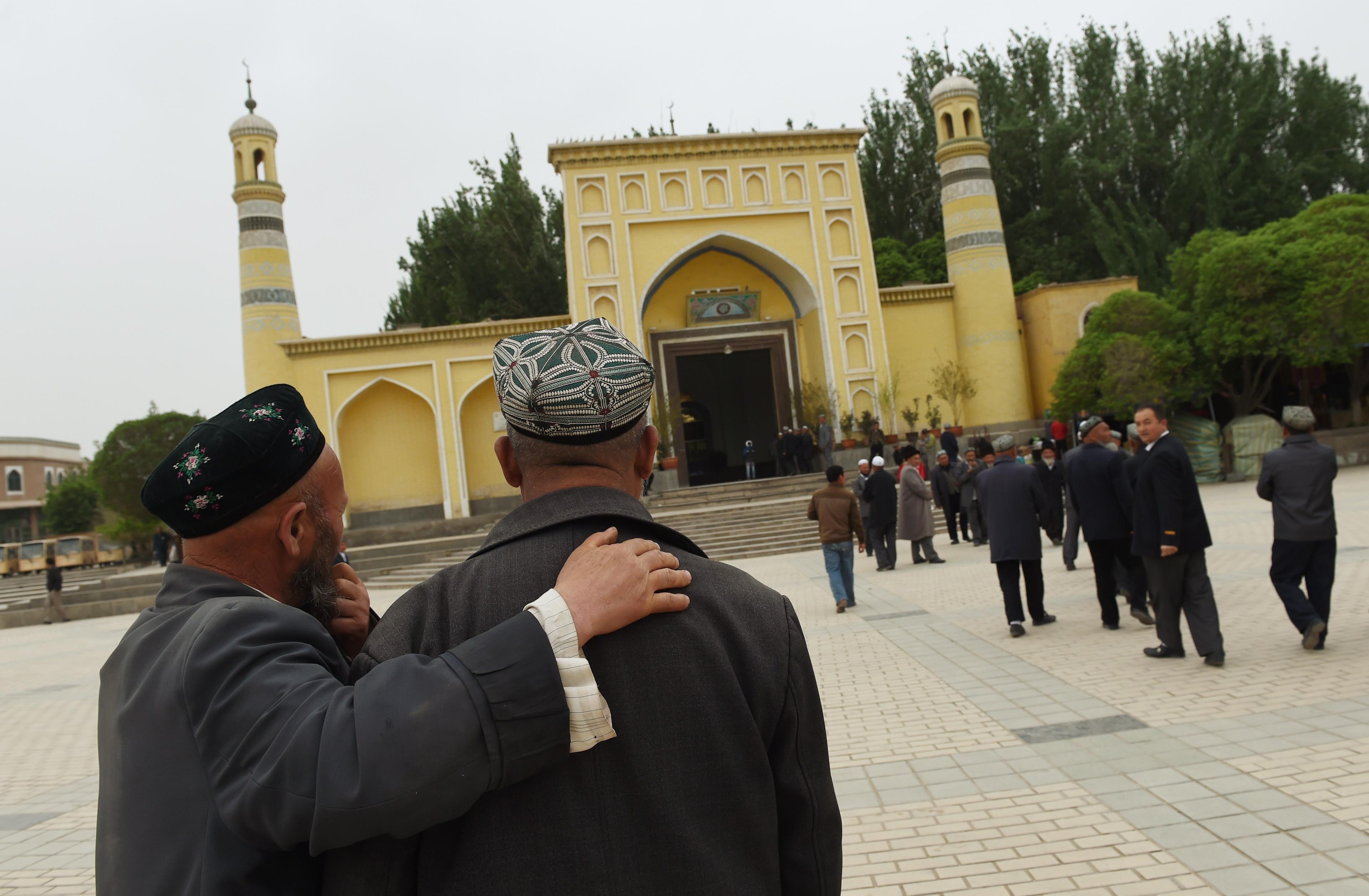 Uigurer  på väg till moskén i staden Kashgar i Xinjiangregionen i Kina. Enligt rapporter tvingas uiguriska män till obetalda dagsverken av den lokala kommunistpartiledningen.   (Greg Baker/AFP/Getty Images)