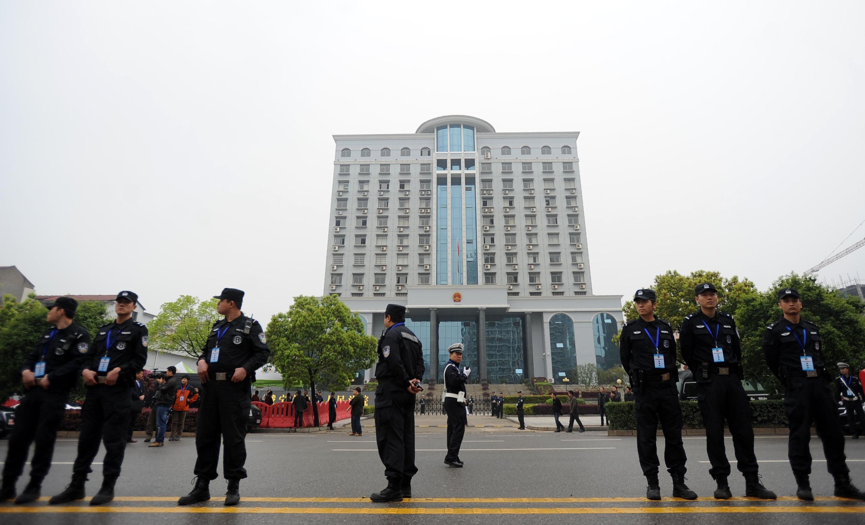 Poliser utanför Xiannings mellandomstol i Hubeiprovinsen. Kina planerar nu ett system för att kontrollera vilka fall olika advokater får ta. (STR/AFP/Getty Images)
