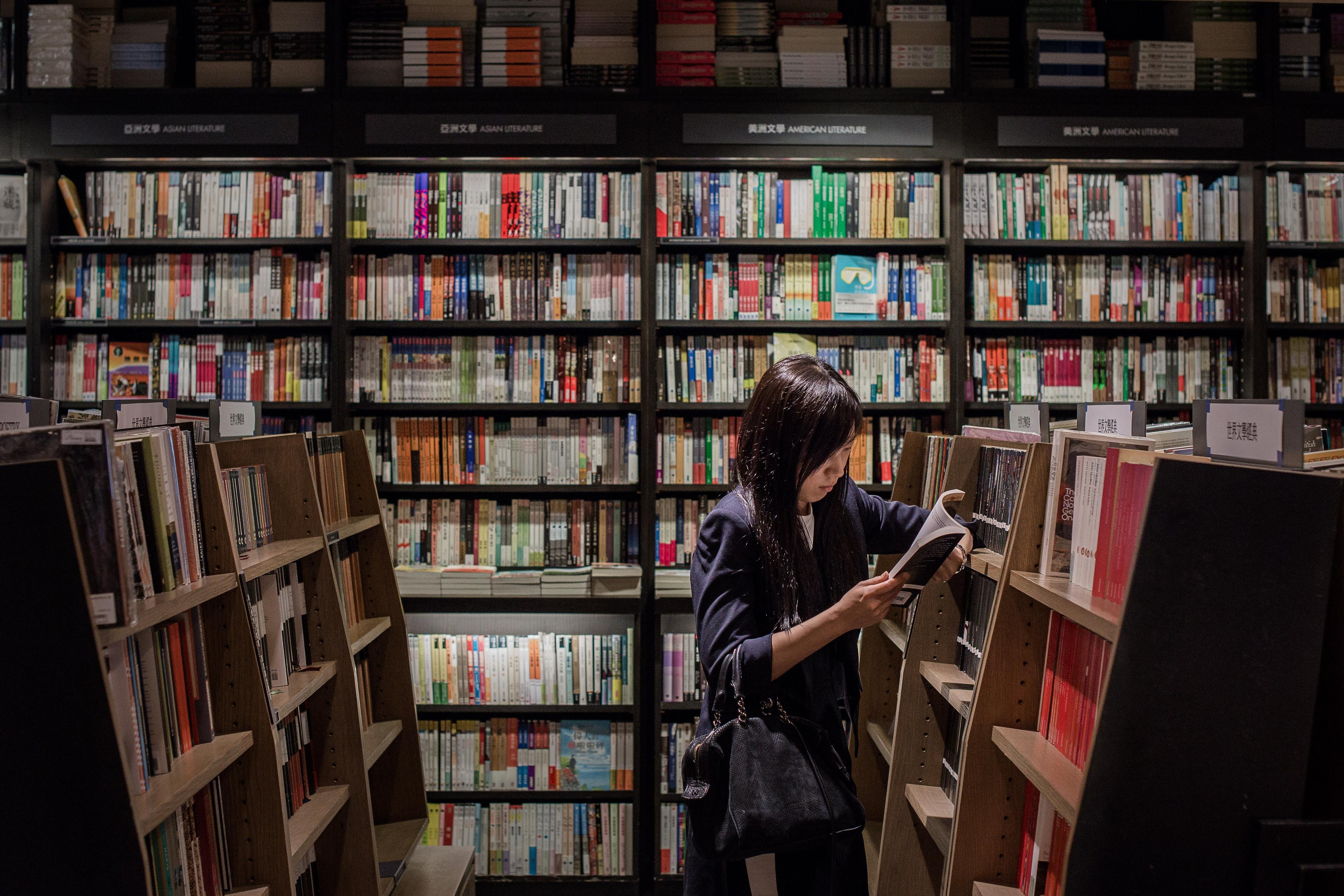 En kinesisk kvinna tittar i en bok i en bokhandel i Hongkong. Den kinesiska bokförläggarföreningens inträde i IPA har väckt starka reaktioner hos de nordiska länderna. (Foto: Philippe Lopez/AFP/Getty Images)