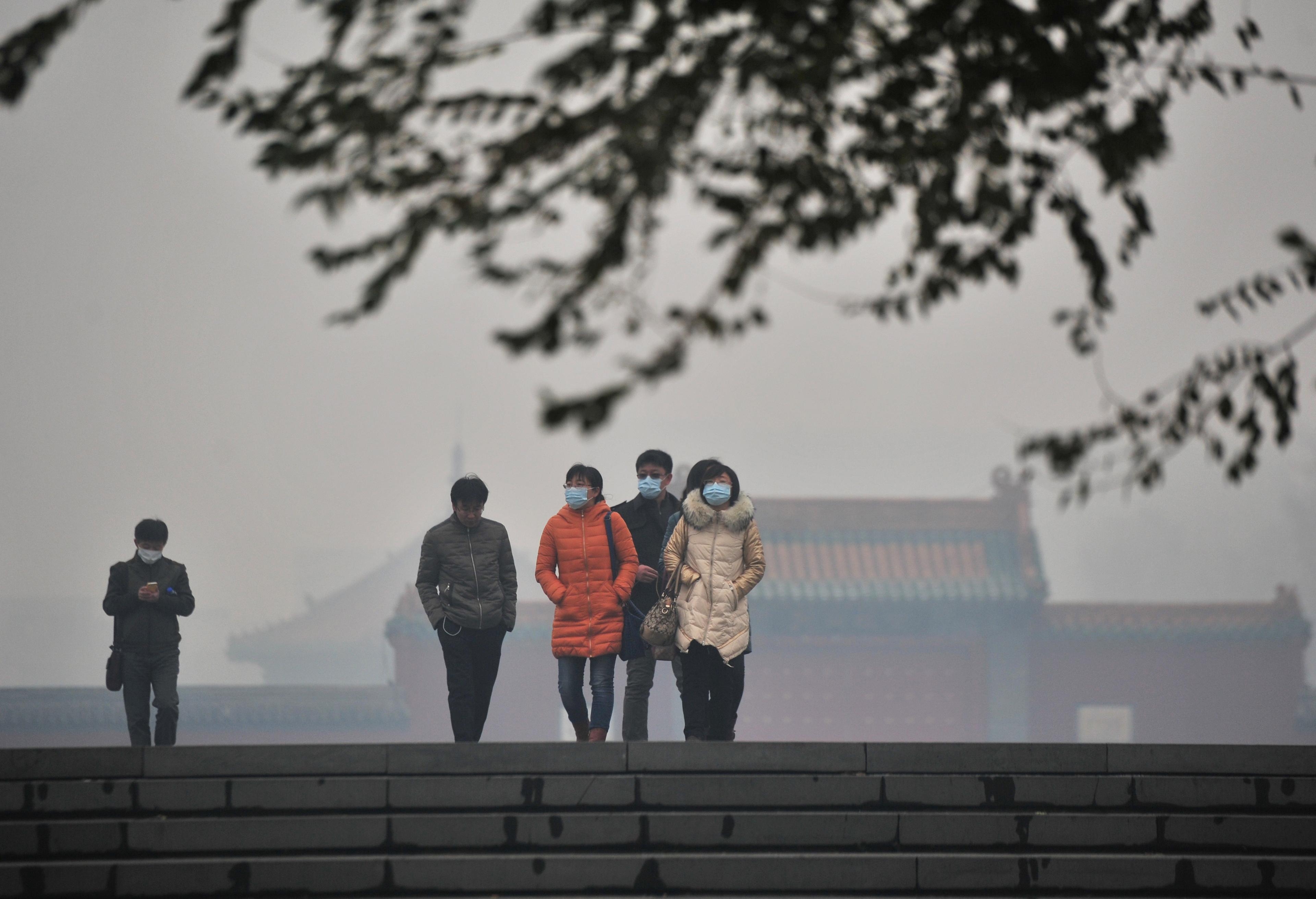 Invånare bär masker bland smogen vid Mukdenpalatset i Shenyang, nordöstra Kina, den 8 november 2015. Tung smog drog in över Kina där partikelhalten PM2,5 var omkring 56 gånger högre än vad WHO anser vara farligt. (Foto: ChinaFotoPress /ChinaFotoPress via Getty Images)