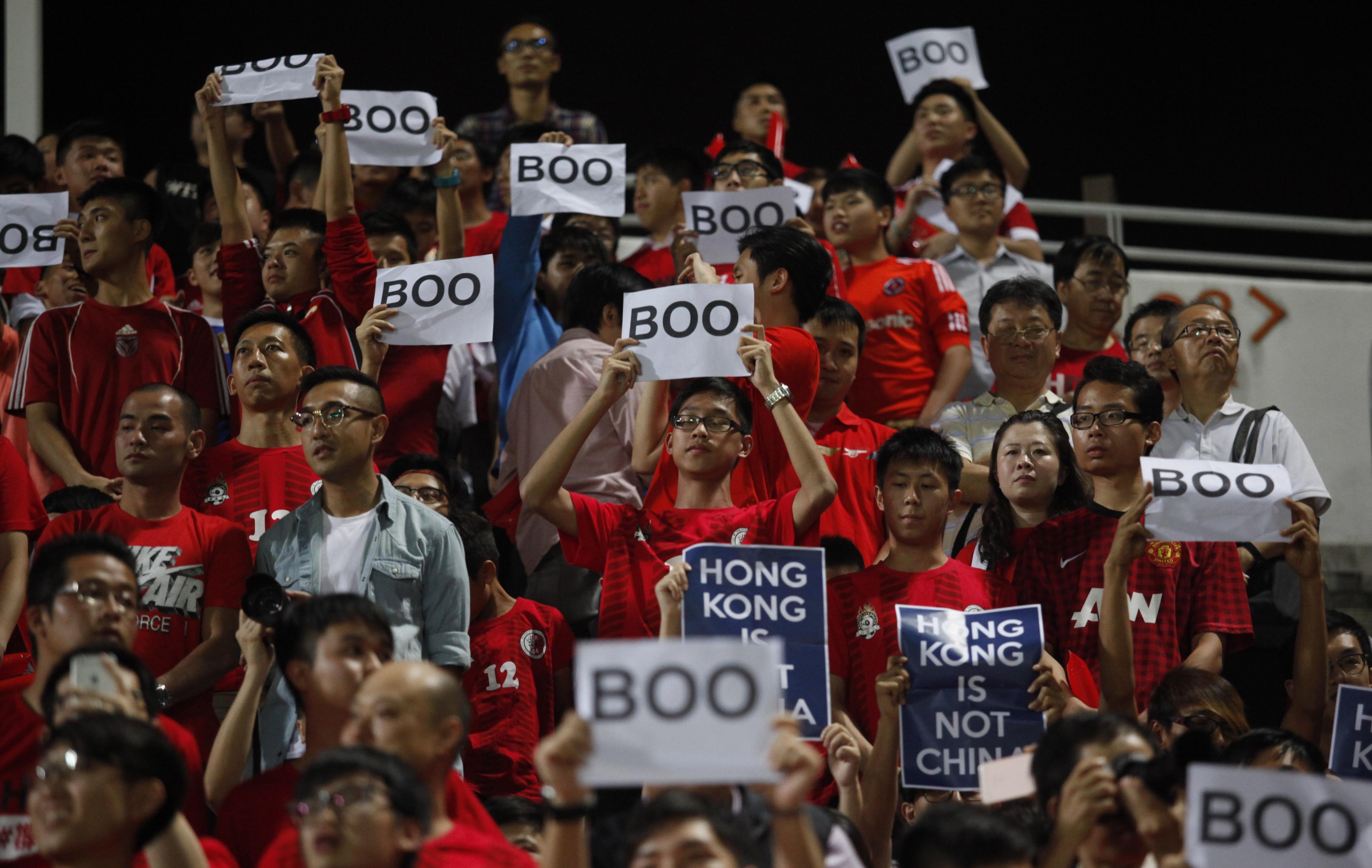 Hongkong fans håller upp skyltar där det står "Boo", samtidigt som nationalsången spelades under en VM-kval på Mongkok stadion i Hongkong den 17 november, 2015. Hongkong fans buade hymnen de delar med Kina, vissa vände ryggen och höll upp "bu"-tecken. (Foto: Isaac Lawrence/AFP/Getty Images)