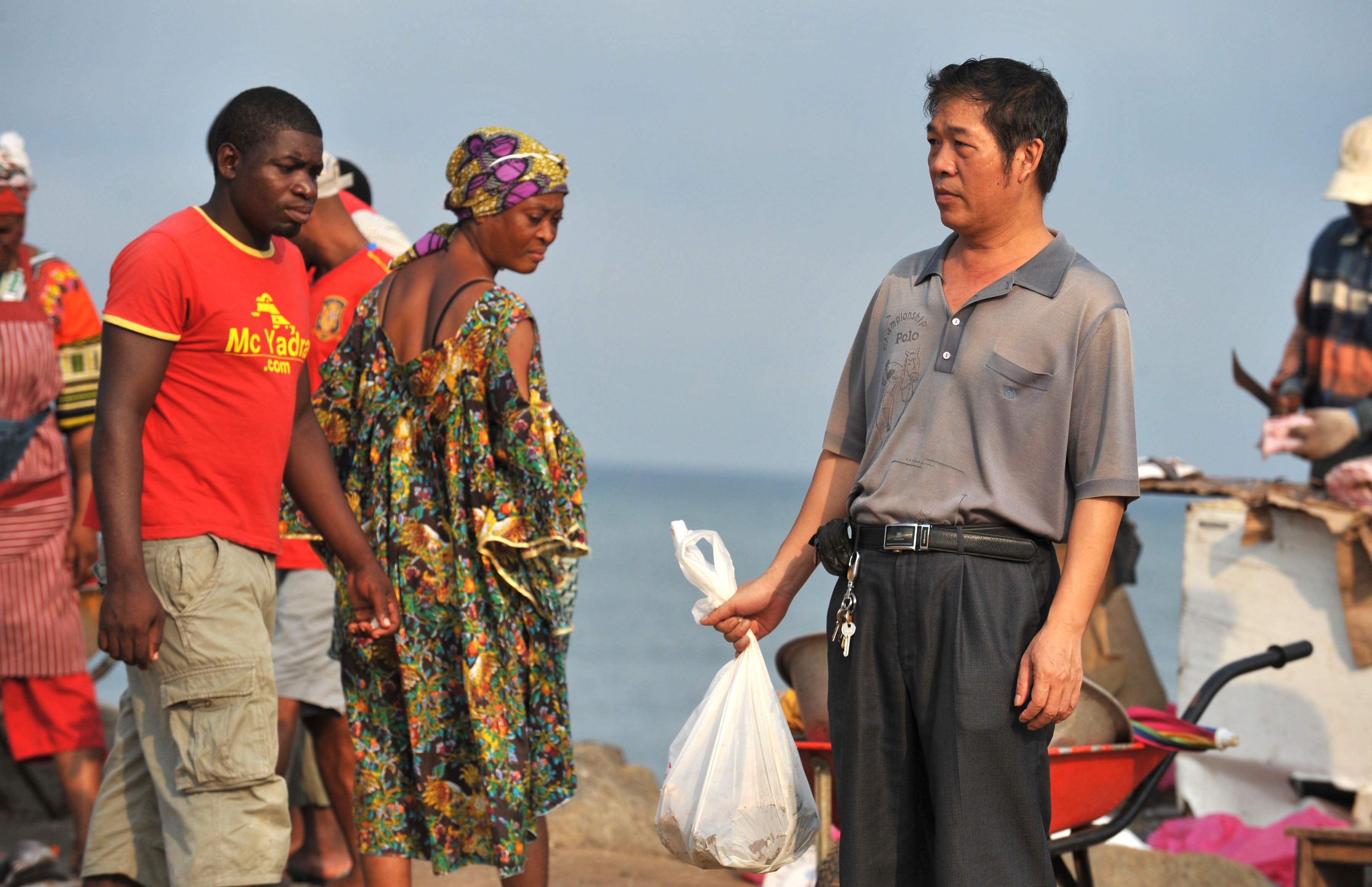 En kines handlar fisk på en marknad i Bata 2012. Kinesiska FDI har markant minskat i Afrika till följd av den kinesiska ekonomiska avmattningen. (Foto: Abdelhak Senna/AFP/Getty Images)
