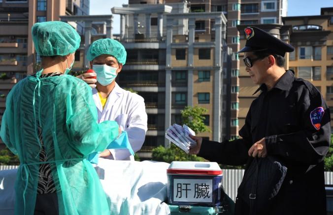 Falungong-utövare spelar upp en scen om organstölder vid en demonstration i Taipei i Taiwan den 20 juli 2014. (Foto: Mandy Cheng/AFP/Getty Image)