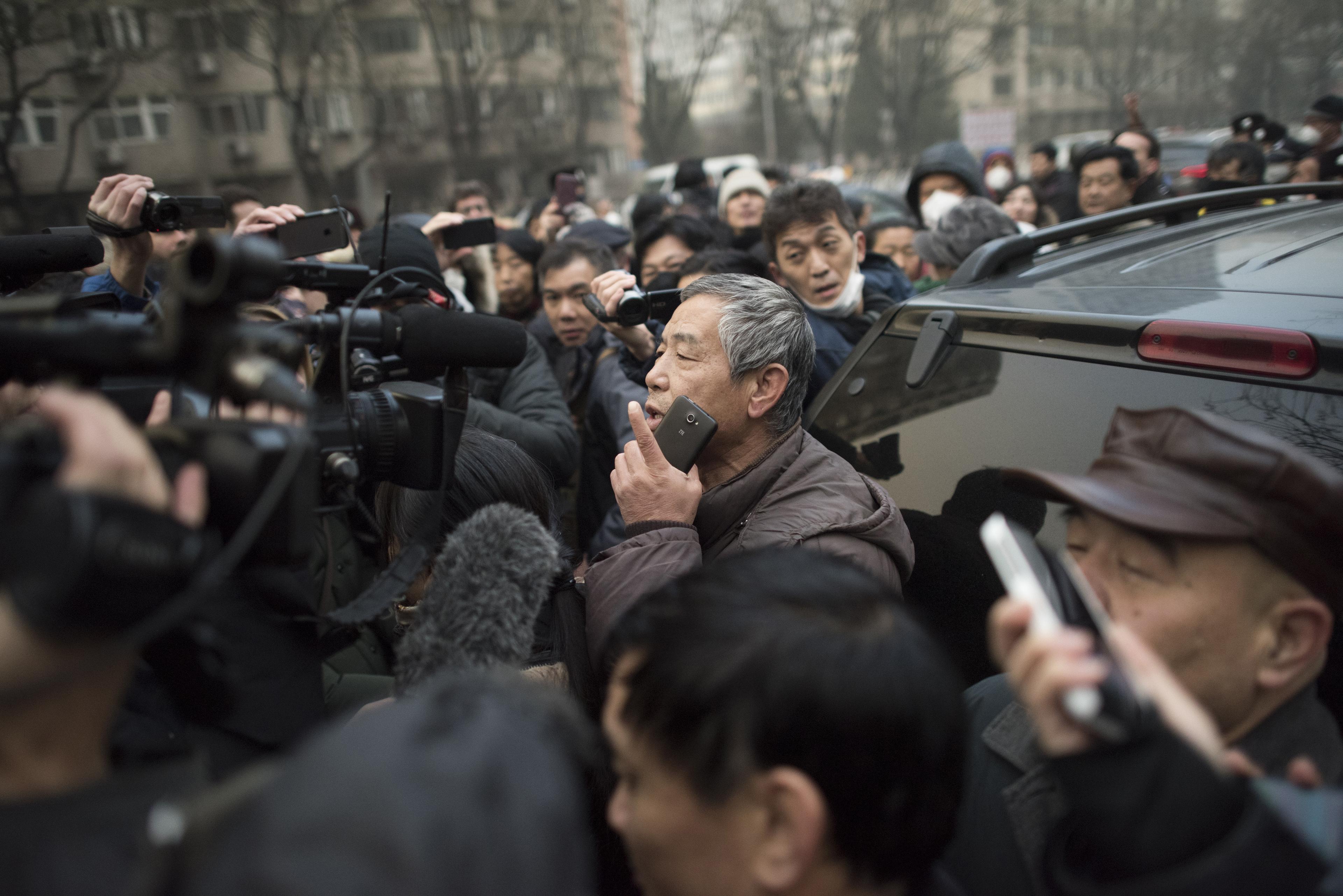 En supporter av människorättsadvokaten Pu Zhiqiang talar till journalister nära Beijing Second Intermediate People's Court in Beijing on December 14, 2015. Polis slog supportrar och journalister som samlats utanför domstolsbyggnaden, när en av Kinas mest berömda människorättsadvokater stod inför rätta, för att ha kommenterat kritiska kommentarer på nätet om det styrande kommunistpartiet.(Foto: Fred Dufour /AFP/ Getty Images)