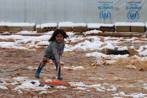 Flyktingkrisen drabbar faktiskt inte bara Sverige, vilket man kan få intrycket av i media. Libanon får ta emot mycket stora mängder flyktingar från det krigsdrabbade grannlandet Syrien. På bilden städar en syrisk flicka bort snö och lera utanför tältet i FN:s flyktingläger i Tal al-Abyad, i närheten av Baalbek i Bekaadalen. (Foto: AFP/Getty Images)