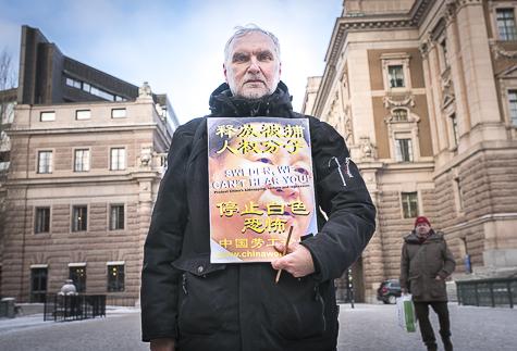 Författaren Per Åke Westerlund protesterade mot Sveriges tystnad till Kina, utanför Sveriges riksdag onsdagen den 20 januari 2016. På plakatet står det: ”Sweden we can’t hear you”. (Foto: Susanne W Lamm/ Epoch Times Sverige)