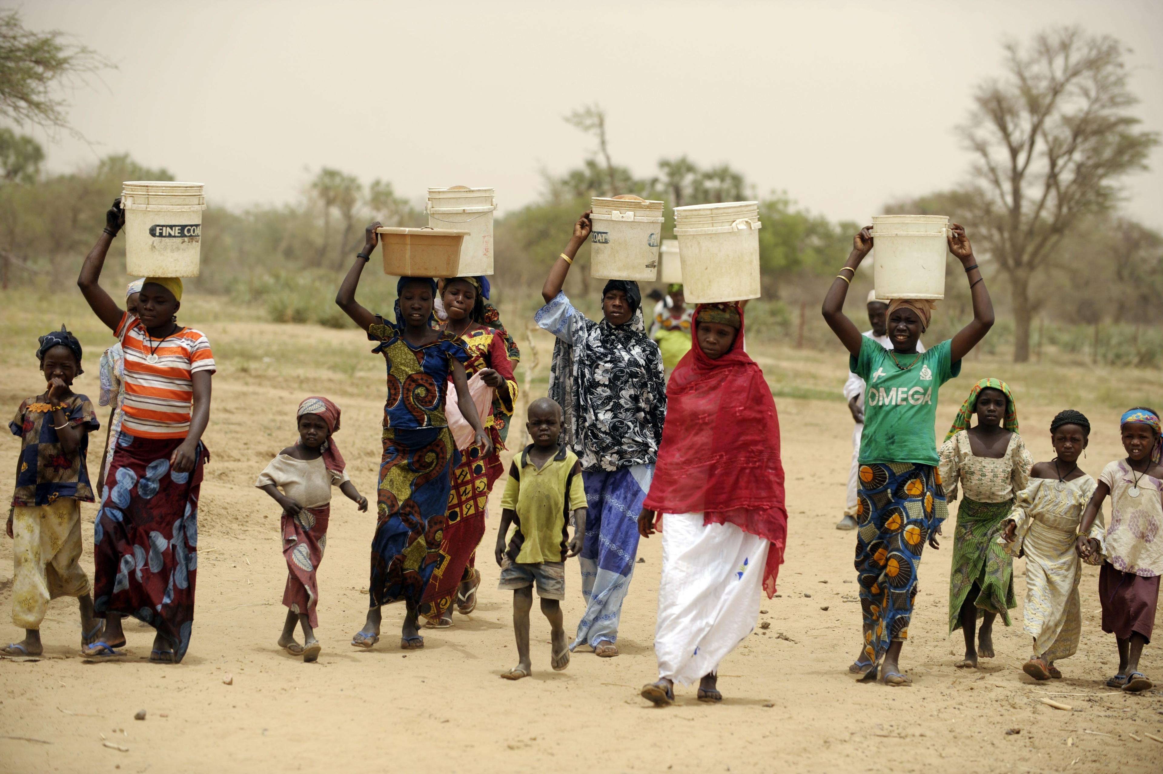 Kvinnor och barn hämtar vatten från en källa i byn Lalari Karfi i Niger. Vatten påverkar allt; utbildning, hälsa och särskilt kvinnor och barn. Det tar tid att bära vatten. Rent vatten på närmare håll ger tid för de unga att studera, så att de kan få ett jobb och tjäna pengar. (Foto: Issouf Sanogo /AFP/Getty Images)