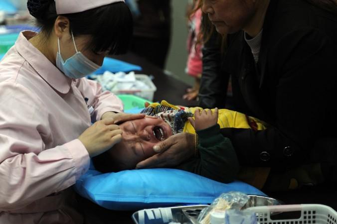 En liten pojke behandlas för influensa i Anhuiprovinsen i Kina. Nu börjar kineser söka sig utomlands för att få vaccin efter att en omfattande handel med osäkra preparat har avslöjats, men myndigheterna i Hongkong har redan agerat mot en möjlig anstormning. (Foto: STR/AFP /Getty Images)