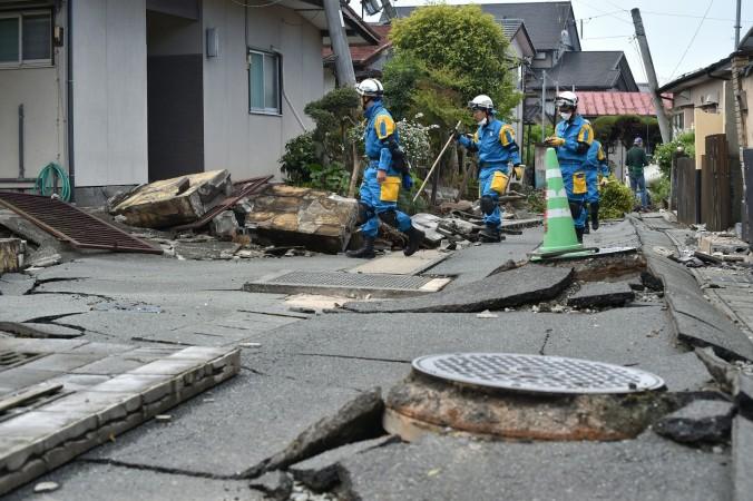 Poliser söker efter överlevande efter jordbävningen i Kumamotoprefekturen i Japan den 17 april. Några kinesiska företag har valt att ”fira” jordbävningen i Japan med olika erbjudanden, vilket lett till ilska. (Foto: Kazuhiro Nogi /AFP/Getty Images)