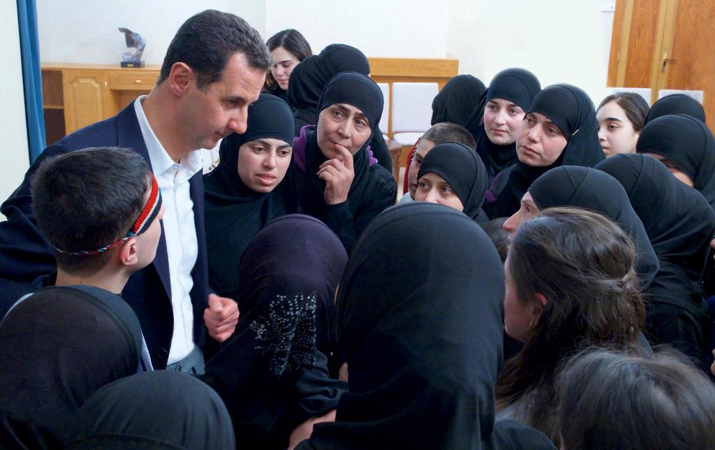 På nyhetsbyrån Sanas bild ses president Bashar al-Assad hälsa på kvinnor som hållits som gisslan av regeringsmotståndare sedan 2013.  Foto: Sana via AP