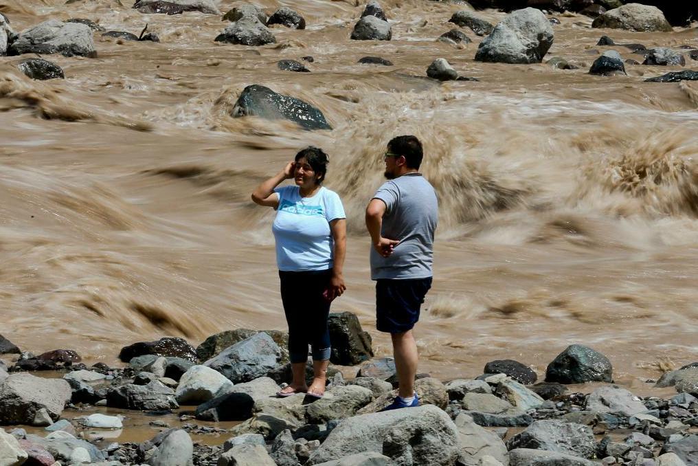 


Ett chilenskt par tittar ut över den översvämmade floden Maipo. Foto: Esteban Felix/AP/TT                                                                                                                                    