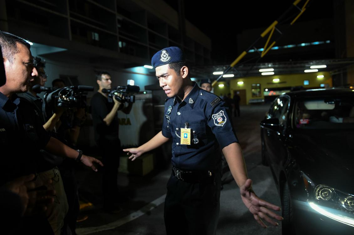 En  malaysisk polis håller tillbaka journalister från det sjukhus i Kuala Lumpur dit den mördade Kim Jong-Nam, halvbror till Nordkoreas diktator Kim Jong-Un togs. Foto: Mohd Rasfan/AFP/Getty Images