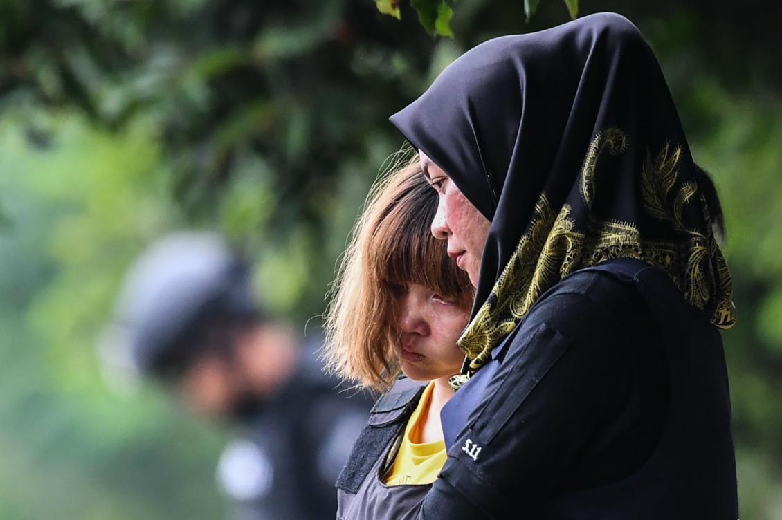 En av de åtalade kvinnorna eskorteras ut från domstolen i Malaysia. Foto: Mohd Rasfan / AFP/Getty Images