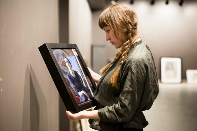 Konstnär Colleen Barry, moderator för utställningen, håller i Hollis Dunlaps självporträtt under förberedelserna inför utställningen "Självporträtt" på Eleventh Street Arts i New York. Foto: Samira Bouaou