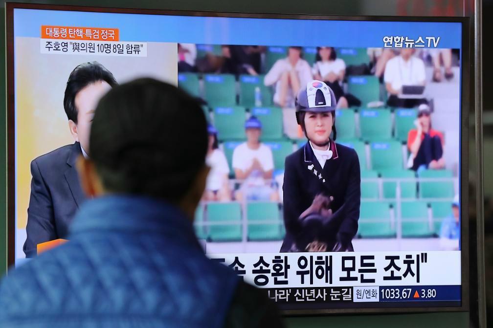 
En sydkoreansk man tittar på ett nyhetsinslag som handlar om Chung Yoo-Ra, som nu utvisas från Danmark. Foto: Lee Jin-man/AP/TT                                            
