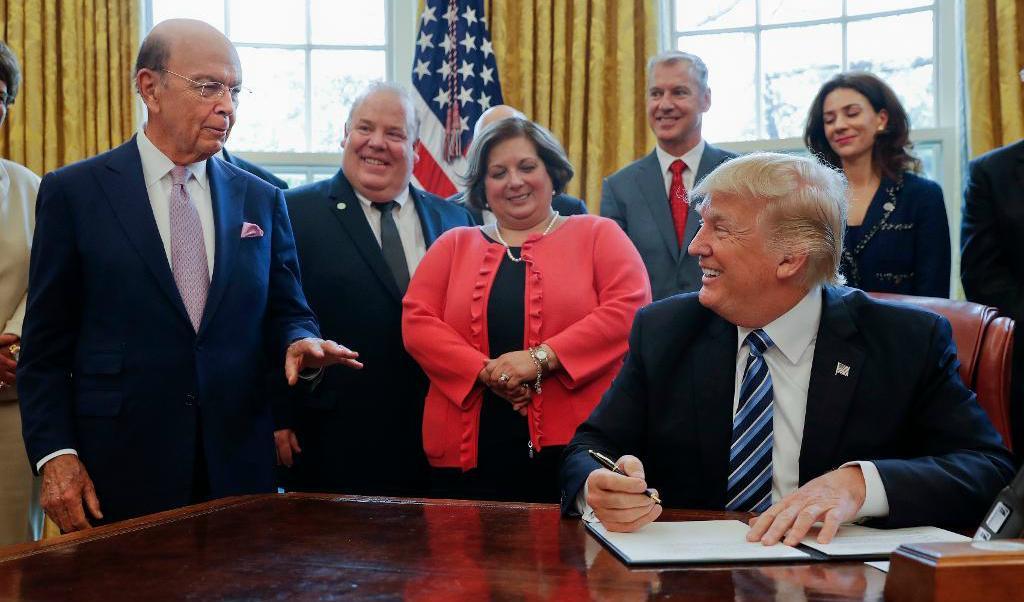 President Donald Trump tittar på handelsminister Wilbur Ross vid ett annat undertecknande i torsdags. Foto:
Pablo Martinez Monsivais/AP/TT