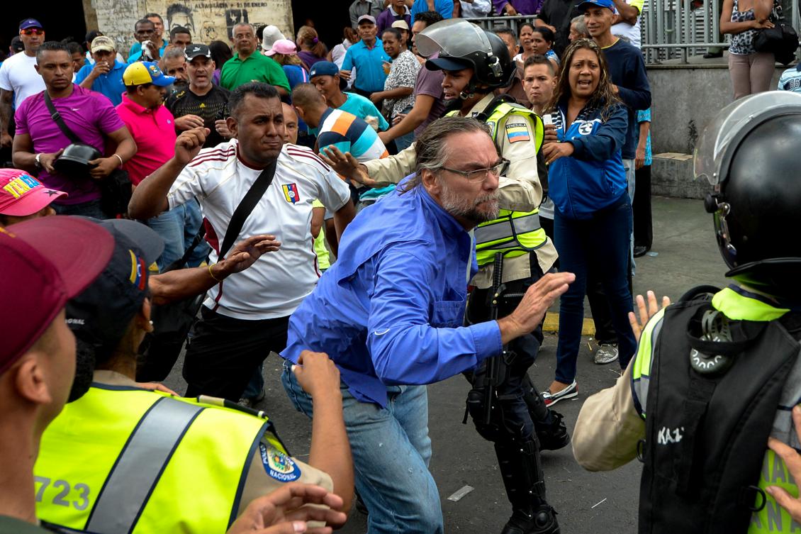 Bråk mellan de som stöder president Nicolas Maduro och oppositionen, framför kyrkan Santa Theresa där en påskprocession skrider fram. Foto: Federico Parra /AFP/Getty Images