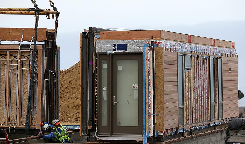 Byggarbetare håller på att installera modulhus i Vallejo i Kalifornien den 27 januari 2014. Modulhusbyggandet i Sverige, som var tänkt att lösa bostadsbristen för asylsökande, har inte direkt blivit någon succé. Istället har det lett till att många projekt har lagts ned då det inneburit skyhöga kostnader och konflikter. Foto: Justin Sullivan/Getty Images