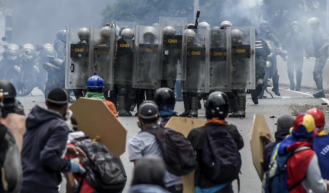 Demonstranter och kravallpolis drabbar samman under protester mot Venezuelas president Nicolas Maduro. Foto: Juan Barreto/AFP/Getty Images.