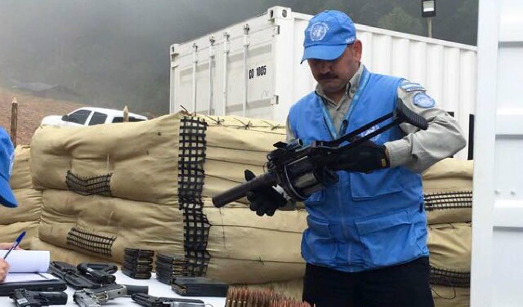 En FN-anställd i Colombia håller i ett vapen som lämnats över av Farc-rebeller. Foto: FN/AP/TT-arkivbild
