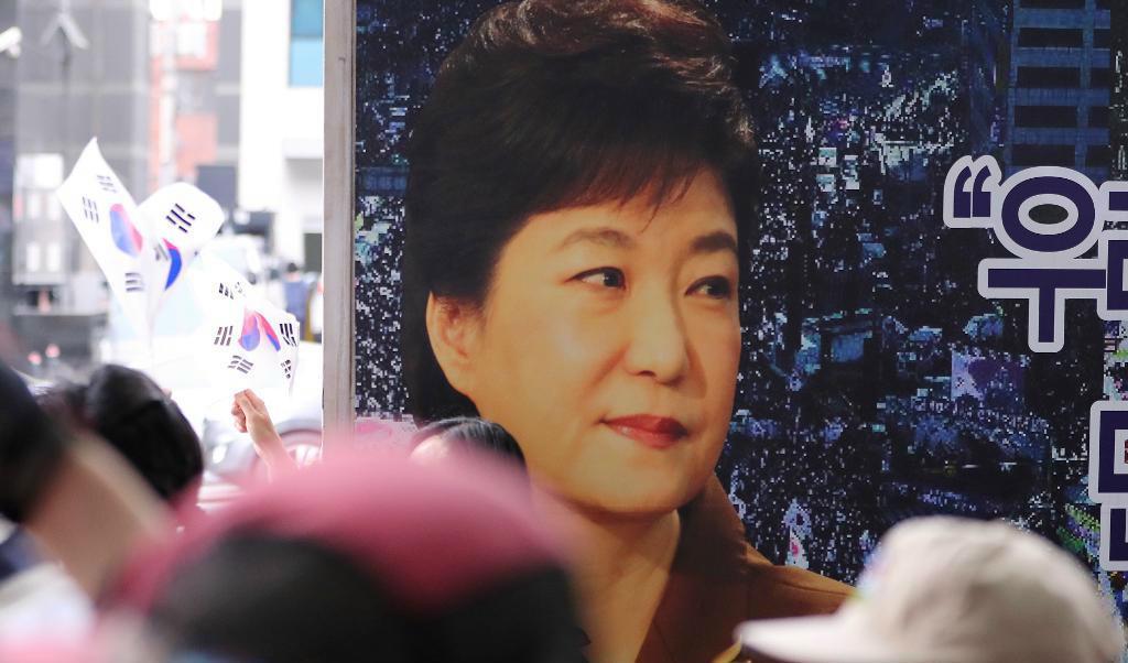 
En bild på Park Geun-Hye bakom anhängare till den avsatta presidenten i samband med en rättsförhandling i Seoul i våras. Foto: Lee Jin-Man                                            