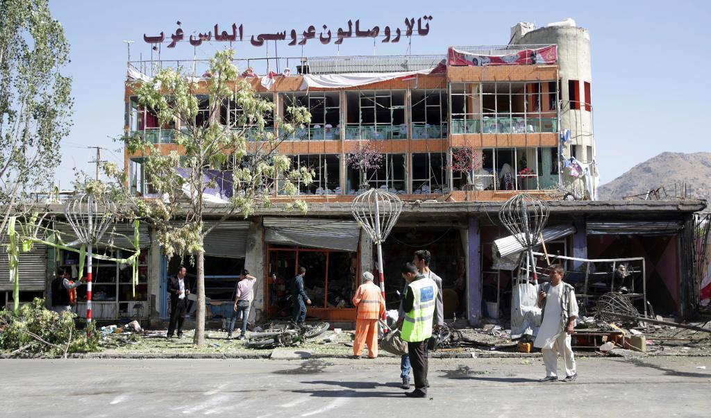 Arbetare städar upp vid platsen för självmordsdådet i Kabul. Foto: Massoud Hossaini/AP/TT