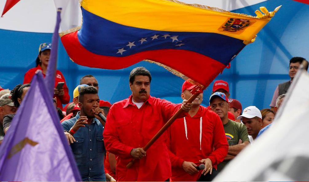
Venezuelas president Nicolás Maduro med en stor flagga under ett tal i Caracas på torsdagen. Foto: Ariana Cubillos/AP/TT                                            