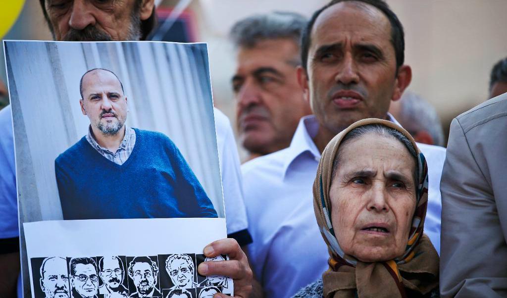 Demonstranter med en bild på den fängslade journalisten Ahmet Sik (stora bilden) och andra journalister som står åtalade misstänkta för medhjälp till terrorism. Bilden är tagen tidigare i veckan. Foto: Lefteris Pitarakis/AP/TT