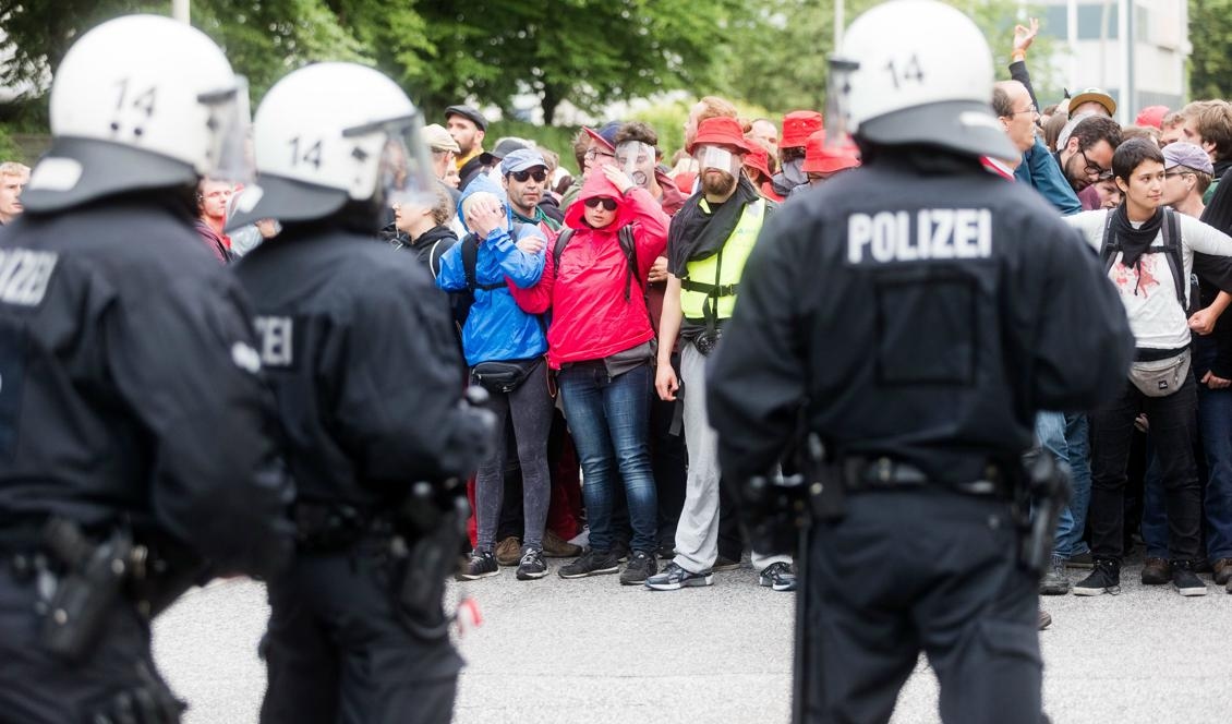 Demonstranter iakttas av tyska poliser i Hamburg där ledarna för världens toppekonomier samlas för ett G20-möte. Foto: Markus Scholz/FP/Getty Images
