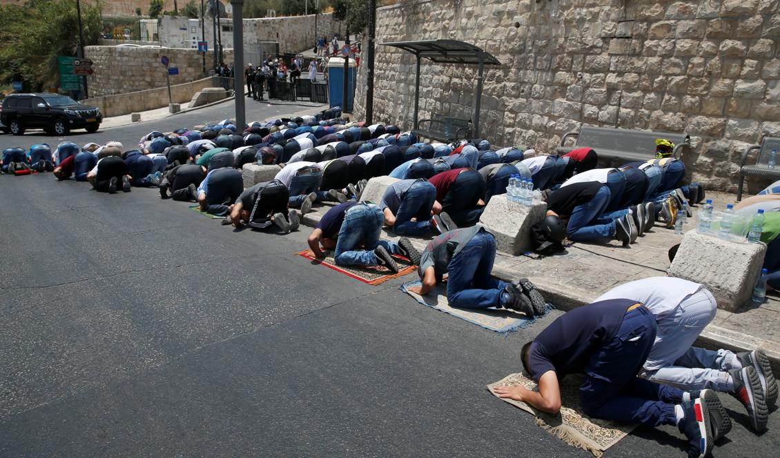 Palestinska muslimer ber utanför Lions port, huvudingången till Al-Aqsa-moske i Jersalems gamla stad den 22 juli 2017. Protester mot israeliska säkerhetsåtgärder efter en attack mot israeliska poliser orsakar våldsamma sammandrabbningar. Foto: Ahmad Gharabli / AFP / Getty Images
