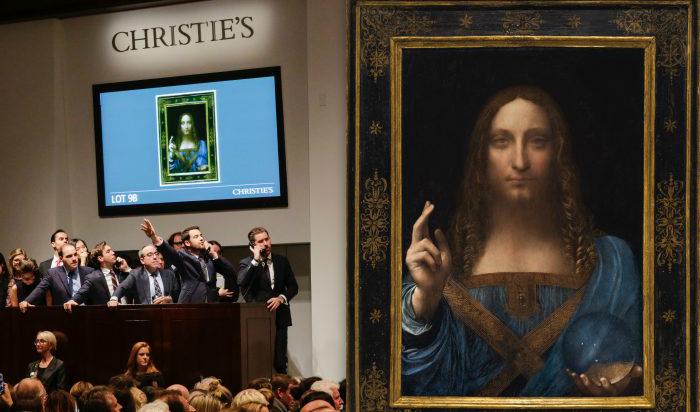 Till vänster: Ombud pratar i telefon med sina klienter medan de lägger bud på auktionen för Leonardo da Vincis "Salvator Mundi" under Post-War and Contemporary Art-försäljningen på Christies den 15 november 2017 i New York. Foto: Eduardo Munoz Alvarez/Getty Images. Till höger: “Salvator Mundi,” ca år 1500, av Leonardo da Vinci (1452–1519). Olja på valnötsträpanel, 66x45,7 cm, privat samling. Foto: Christie’s