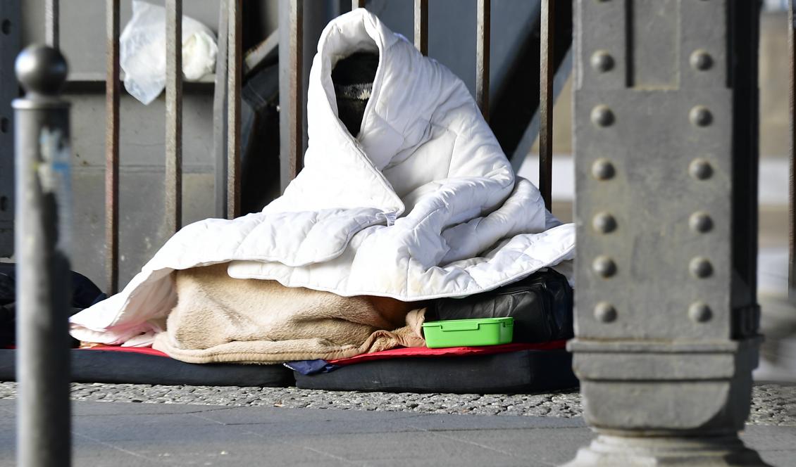 En man sitter insvept i ett täcke i kylan i Berlin 1 mars 2018. Regeringen tänker avsätta 120 miljoner till ensamkommande unga i Sverige under en treårsperiod. Foto: Tobias Schwarz/AFP/Getty Images