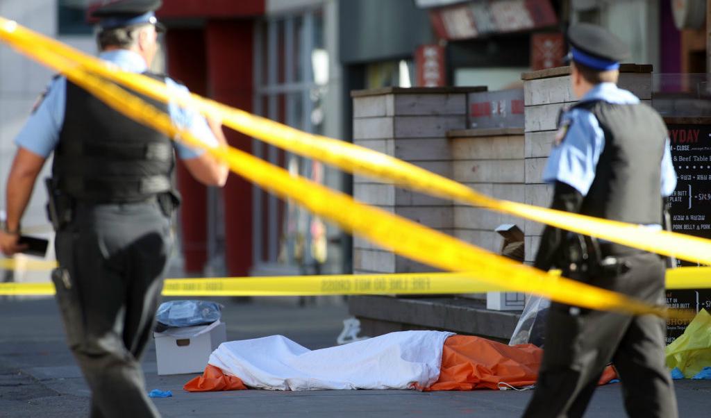 Poliser framför en av de döda personerna på gatan efter att skåpbilen körde in i en folkmassa i Toronto, Kanada den 23 april. 2018. Foto: Lars Hagberg/AFP/Getty Images