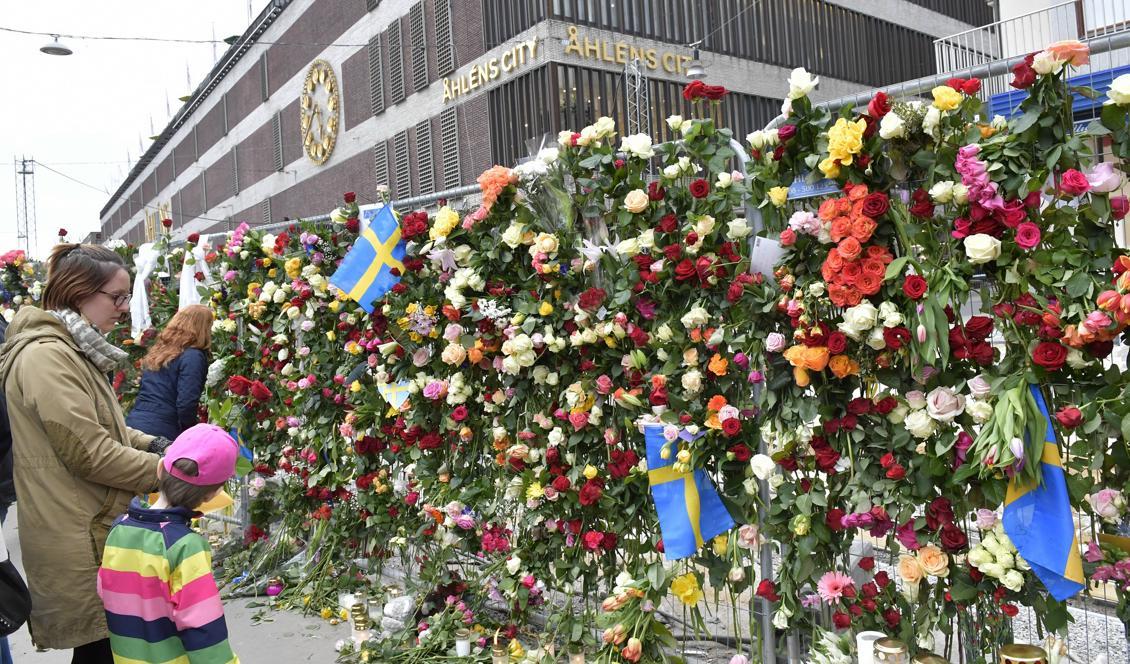 Människor besöker avspärrningarna vid Åhléns City i centrala Stockholm dagen efter terrordådet på Drottninggatan i april i fjol. Foto: Jonas Ekströmer/TT-arkivbild