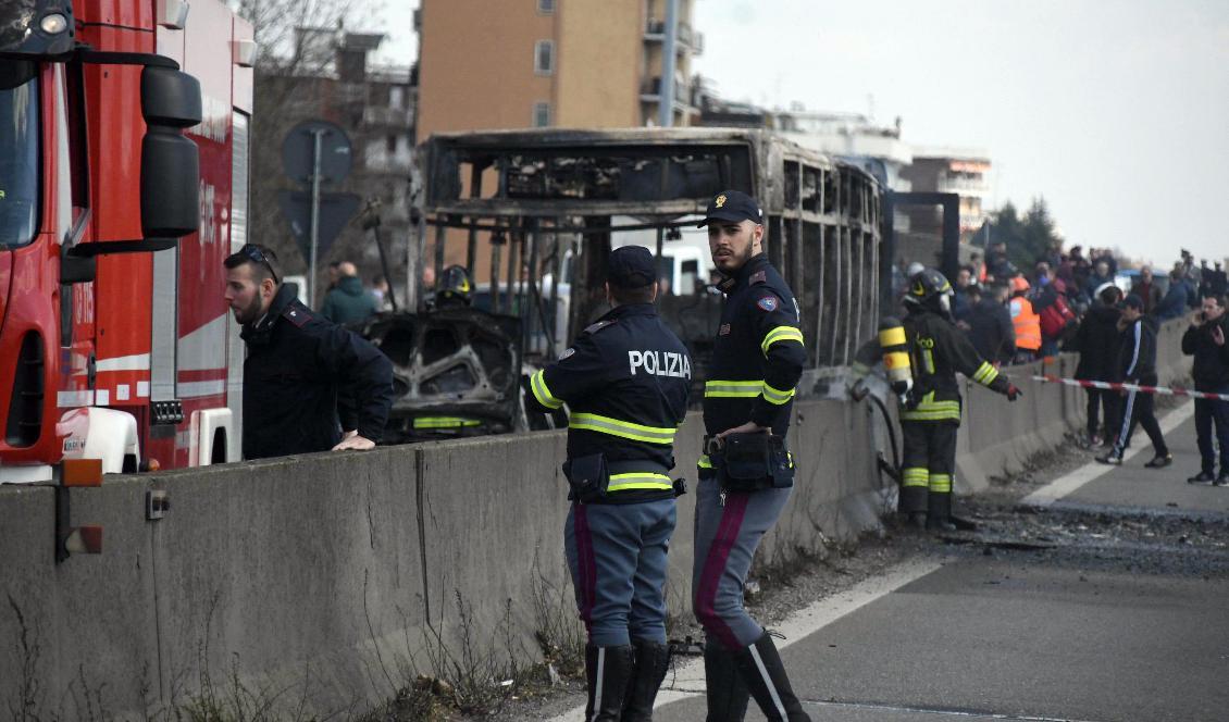 
Polis och brandkår utanför den utbrända bussen. Foto: Daniele Bennati/AP/TT                                                