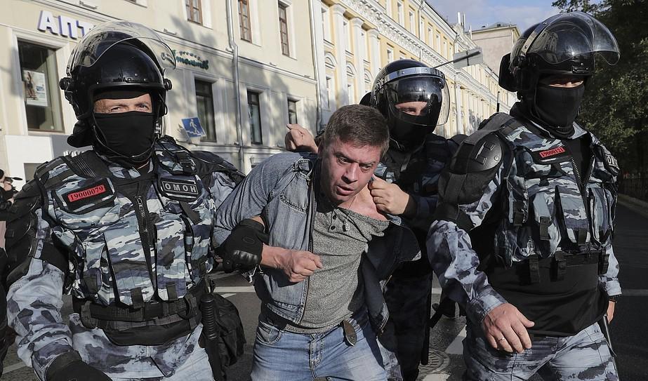 Polisen griper en demonstrant i samband med en demonstration i Moskva under lördagen. Foto: AP/TT-arkivbild