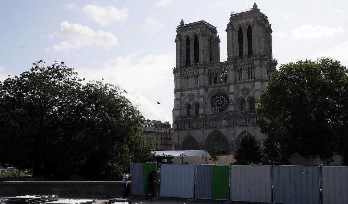 Katedralen Notre Dame i Paris döljs av höga avspärrningar. Bakom dem ska området blysaneras. Foto: Francois Mori/AP/TT