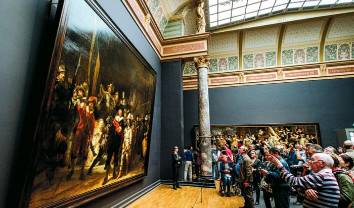Besökare på Rijksmuseum i Amsterdam tittar på Rembrandts "Nattvakten" 17 maj 2015. Foto: Robin Van Lonkhuijsen/AFP/Getty Images