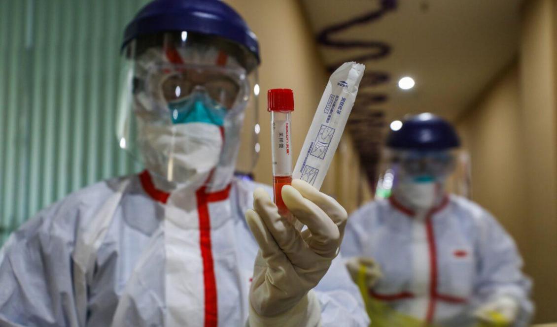 Personal i en karantänzon i Wuhan visar ett prov efter att ha tagit prov på en patient som misstänks ha smittats av coronaviruset, den 4 februari 2020. Foto: STR/AFP via Getty Images