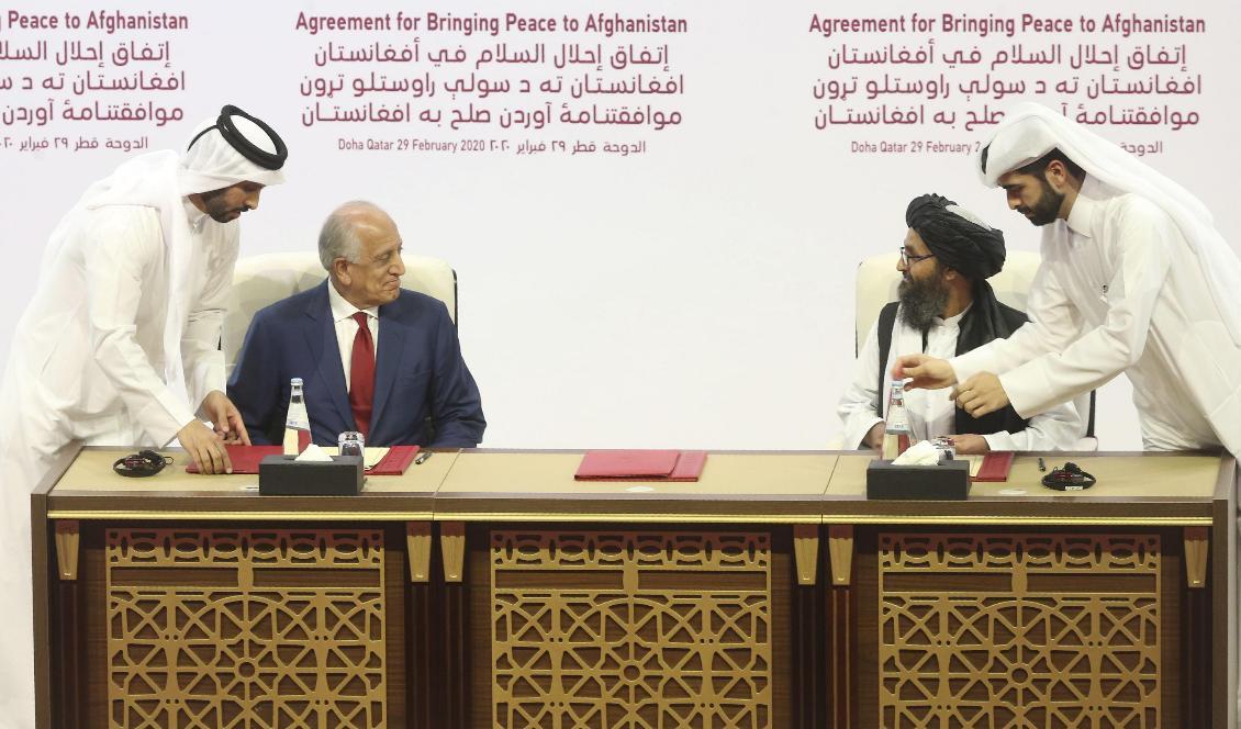 USA:s representant Zalmay Khalilzad och talibanernas mulla Abdul Ghani Baradar vid undertecknandet av en fredsuppgörelse. Överenskommelsen fattades i Doha den 29 februari. Foto: Hussein Sayed/AP/TT-arkivbild
