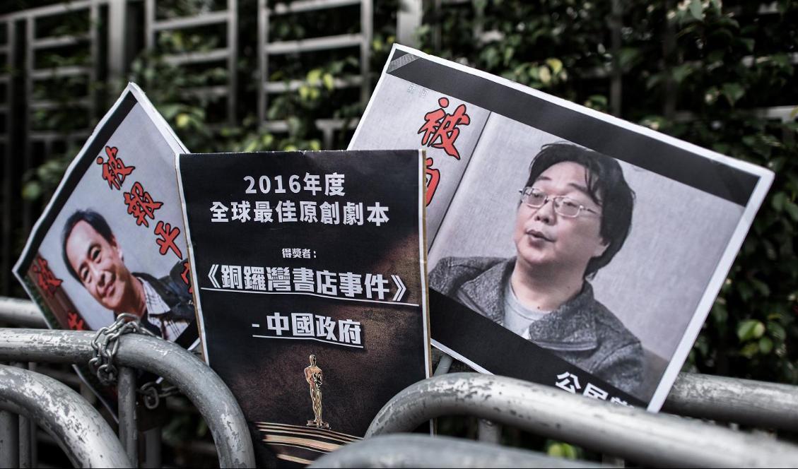 På plakaten syns bokhandlaren Lee Bo till vänster. Svensk-kinesiske Gui Minhai syns till höger. Bilden är tagen utanför Kinas sambandskontor i Hongkong den 19 januari 2016. Foto: Philippe Lopez/AFP via Getty Images